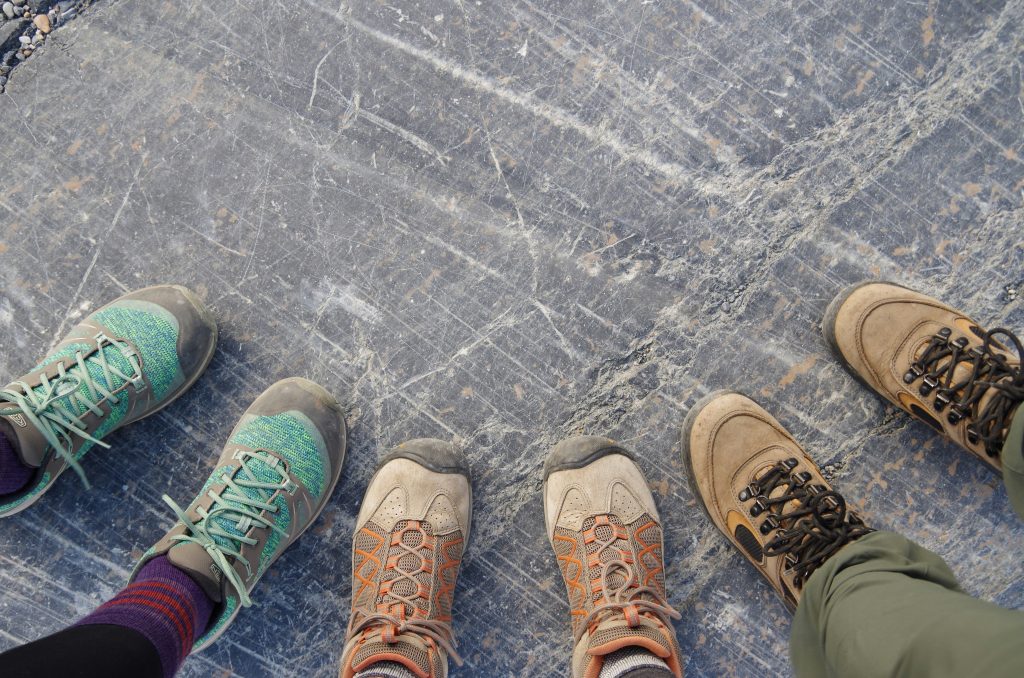 Close-up of hiking boots trekking through deep snow on a forest trail, demonstrating winter traction and waterproof features