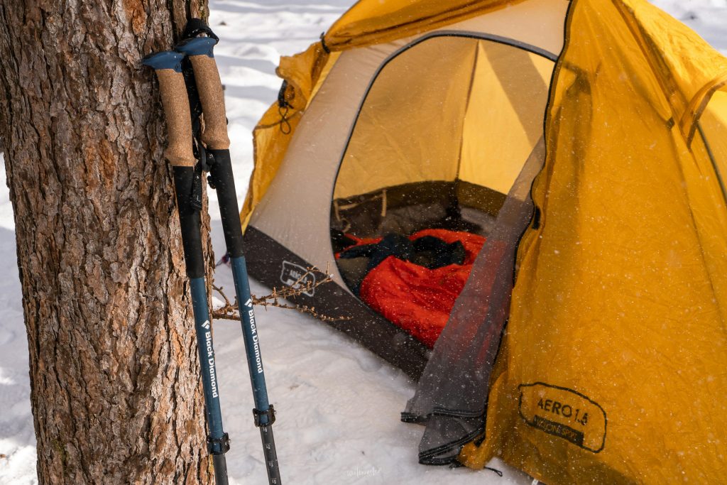 Hiker using adjustable trekking poles for balance on rocky mountain trail descent